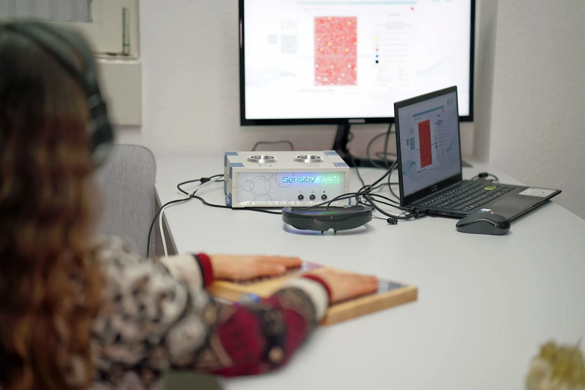 Patientin bei der SensitivE-Audit-Diagnostik vor zwei Bildschirmen